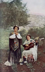 Spanien. Medan hennes kamrat spelar gitarr klappar den unga flickan lätt i händerna. De flesta spanska dansare föredrar denna form av ackompanjemang. 1920